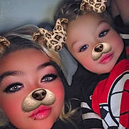Hunter joined the competition — help win amazing prizes! child, person, face_filter, dog_filter, leopard_ears, nose_filter, closeup, lying_down, smiling, casual_clothing, indoor, dim_lighting, makeup, blush, eyelashes, red_shirt, black_shirt, graphic_tshirt, two_people, fun_filter