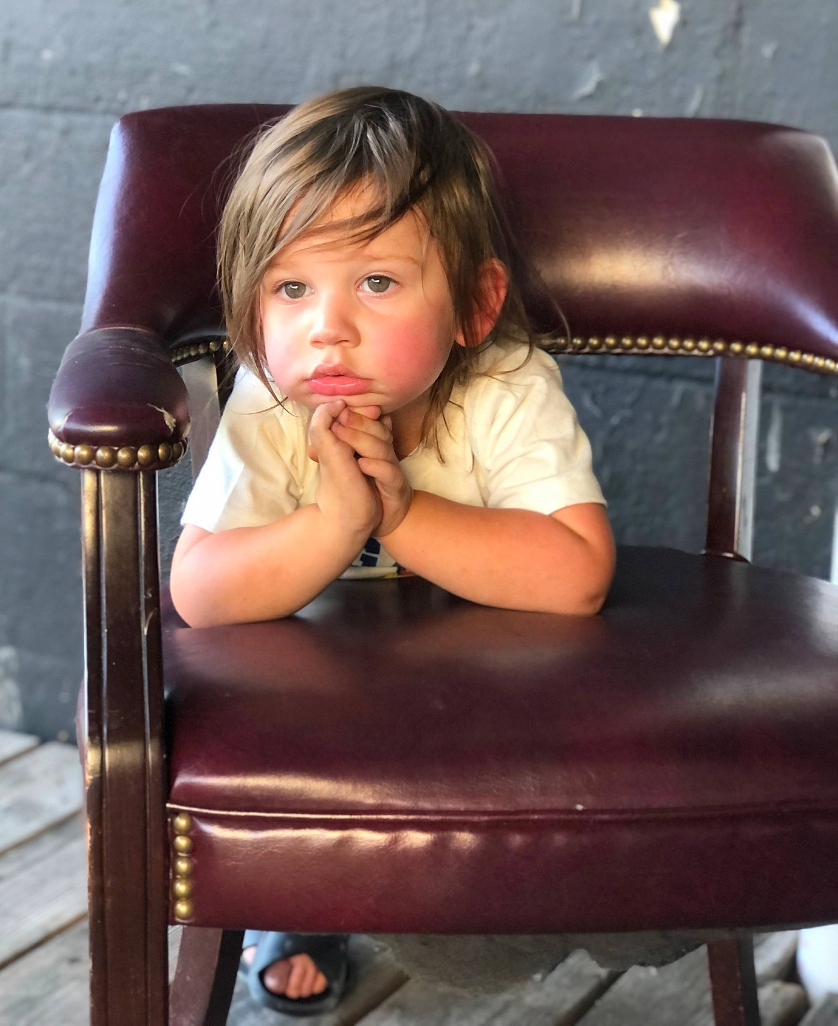 Reznor is registered to the contest to win money with this photo: arm, chair, cheek, child, chin, comfort, eyelash, facial_expression, finger, flash_photography, furniture, hair, hairstyle, human_body, human_leg, lip, person, sitting, skin, toddler
