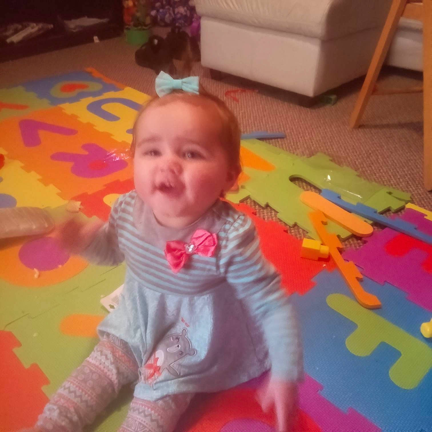 Isabella is registered to the contest to win money with this photo: baby, baby_toddler_clothing, carpet, cheek, child, eye, floor, flooring, fun, happy, hardwood, head, houseplant, iris, orange, person, room, smile, standing, toddler