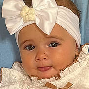 Marley participe au concours pour gagner de l'argent avec cette photo : adorable, baby, bow, child, closeup, clothing, cute, earrings, expression, eyes, face, fashion, headband, indoor, infant, person, portrait, ruffles, skin, tongue
