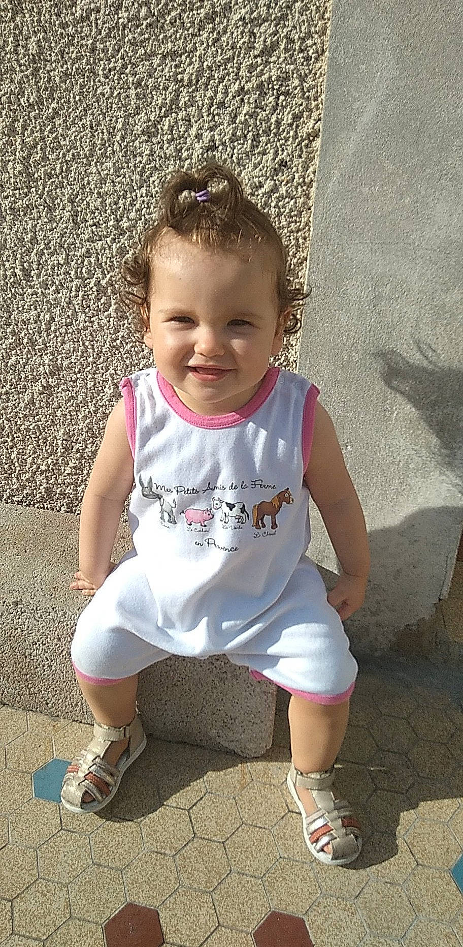 Ashley a rejoint le concours — aidez-le/la à gagner de superbes lots ! baby, baby_toddler_clothing, cheek, child, concrete, fun, grass, happy, human_leg, joy, lip, pattern, person, pink, sandal, sitting, sleeve, smile, t_shirt, toddler