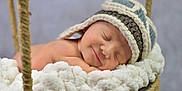 Deaklen is registered to the contest to win money with this photo: baby, sleeping, knitted_hat, blanket, basket, swing, cozy, soft, infant, peaceful, cute, smile, face, skin, child, rest, portrait, warm, comfort, indoors
