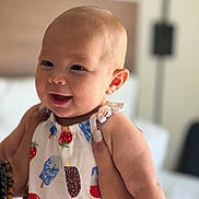 Haven is registered to the contest to win money with this photo: baby, child, smiling, face, person, clothing, pattern, ice_cream, popsicle, indoor, soft_light, hand, holding, happy, cute, infant, head, skin, apparel, young