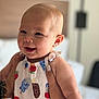 baby, child, smiling, face, person, clothing, pattern, ice_cream, popsicle, indoor, soft_light, hand, holding, happy, cute, infant, head, skin, apparel, young
