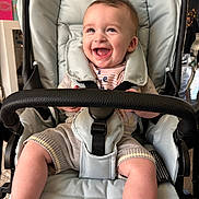 Connor joined the competition — help win amazing prizes! baby, smiling, stroller, child, happy, infant, seat, clothing, indoor, person, cute, expression, comfort, young, portrait, sitting, face, baby_girl, baby_boy, infant_clothing
