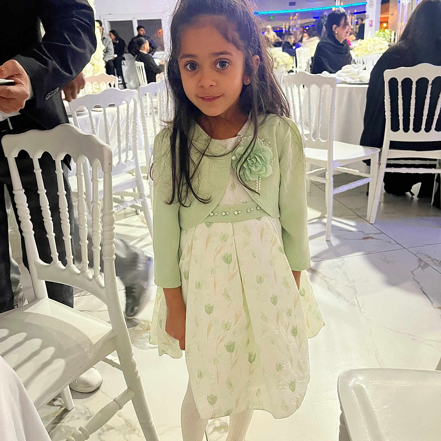 Cassie a rejoint le concours — aidez-le/la à gagner de superbes lots ! child, girl, dress, cardigan, white_chair, event, indoor, floor, people, table, lighting, smile, long_hair, white_shoes, tights, decor, portrait, standing, curious, fashion