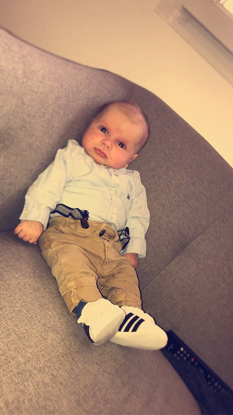 Aaron a rejoint le concours — aidez-le/la à gagner de superbes lots ! baby, baby_toddler_clothing, cheek, child, comfort, eye, floor, flooring, foot, hardwood, human_leg, knee, person, room, sitting, skin, sleeve, standing, tints_and_shades, toddler