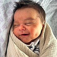 Anthony joined the competition — help win amazing prizes! baby, smiling, sleeping, wrapped, blanket, newborn, infant, face, cute, soft, cozy, child, pattern, fabric, head, peaceful, resting, indoors, portrait, closeup