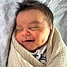 baby, smiling, sleeping, wrapped, blanket, newborn, infant, face, cute, soft, cozy, child, pattern, fabric, head, peaceful, resting, indoors, portrait, closeup