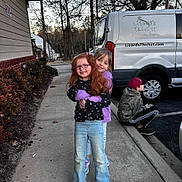 Chloe is registered to the contest to win money with this photo: boy, building, child, children, curb, friends, girl, glasses, hugging, jacket, jeans, outdoor, parking_lot, red_hair, sidewalk, smile, sneakers, trees, van, vehicle