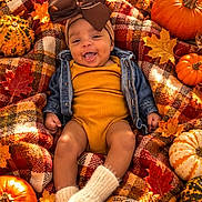 Emanii is registered to the contest to win money with this photo: baby, infant, child, smiling, autumn, fall, pumpkins, gourds, leaves, blanket, plaid, bow, headband, orange, portrait, lying_down, outdoor, seasonal, cozy, photography