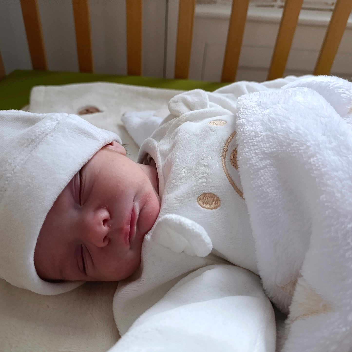 Soën participe au concours pour gagner de l'argent avec cette photo : baby, bed, blanket, bonnet, clothing, cradle, crib, face, furniture, hat, head, indoors, infantbed, newborn, nursery, person, room, sleeping, towel