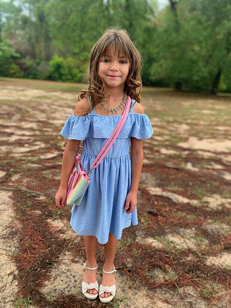 Josie is registered to the contest to win money with this photo: child, day_dress, denim, dress, electric_blue, face, footwear, grass, hair, happy, joy, leaf, pattern, people_in_nature, person, plant, shoe, sleeve, smile, toddler