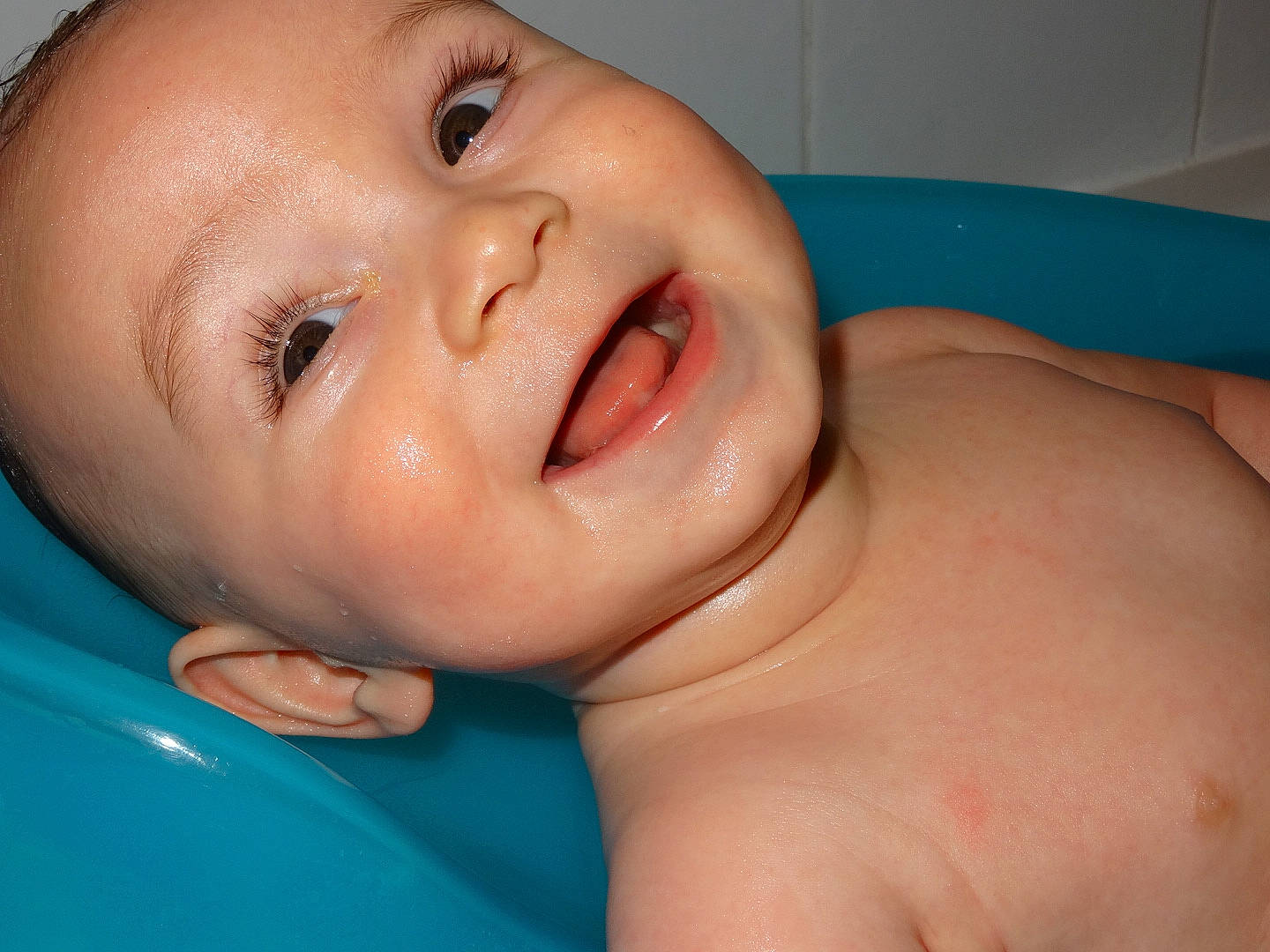 Mylho participe au concours pour gagner de l'argent avec cette photo : baby, baby_bathing, bathing, bathtub, blue, cheek, ear, eyebrow, eyelash, finger, fluid, human_body, iris, lip, mouth, neck, nose, person, skin, smile