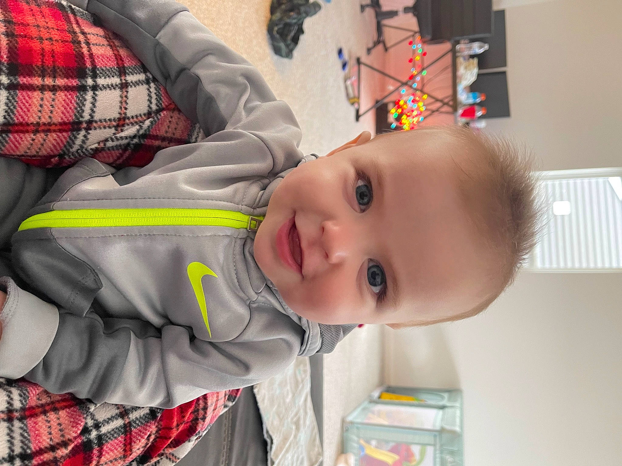 Hudson is registered to the contest to win money with this photo: baby, baby_products, baby_toddler_clothing, child, comfort, happy, nose, pattern, person, plaid, room, sleeve, smile, tartan, toddler