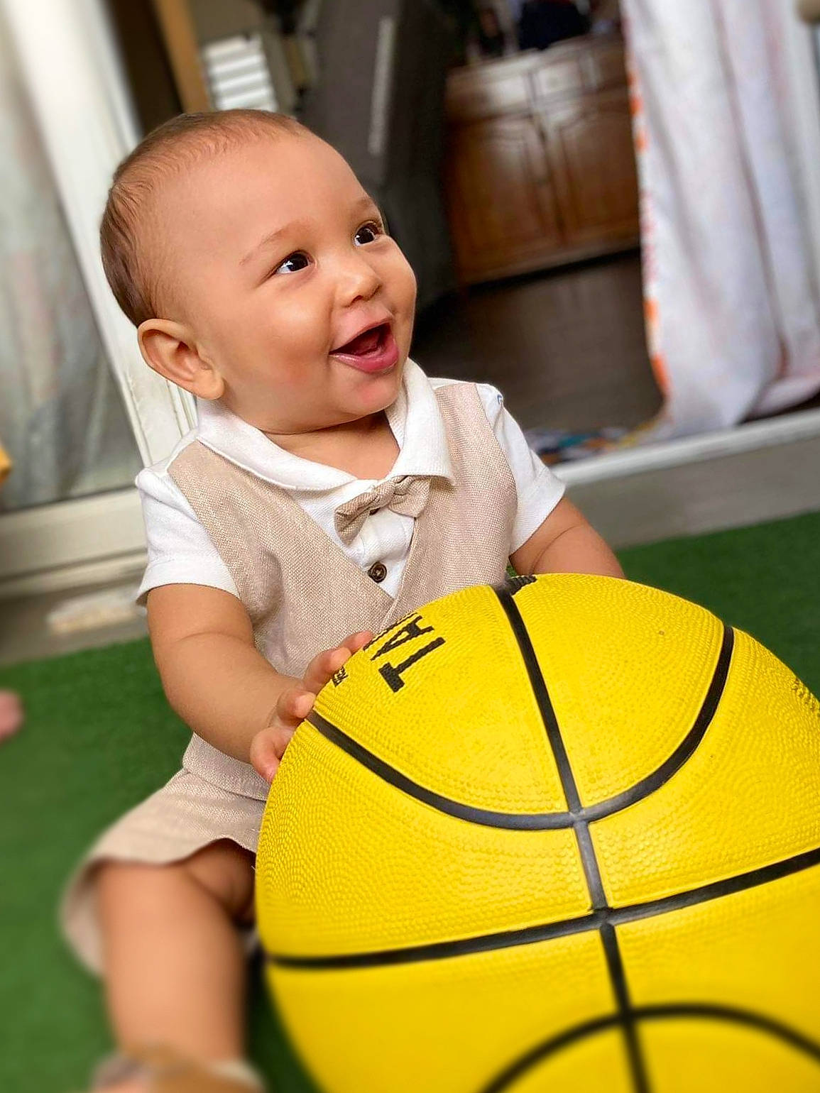 Liam a rejoint le concours — aidez-le/la à gagner de superbes lots ! baby, baby_toddler_clothing, ball, basketball, black, cheek, child, curtain, eye, facial_expression, flooring, football, fun, grass, happy, leisure, person, player, smile, sports_equipment