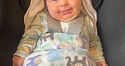 Ember joined the competition — help win amazing prizes! baby, smiling, blanket, car_seat, infant, face, child, happy, clothing, animal_print, cozy, seatbelt, indoors, cute, portrait, hood, person, young_child, comfort, warm