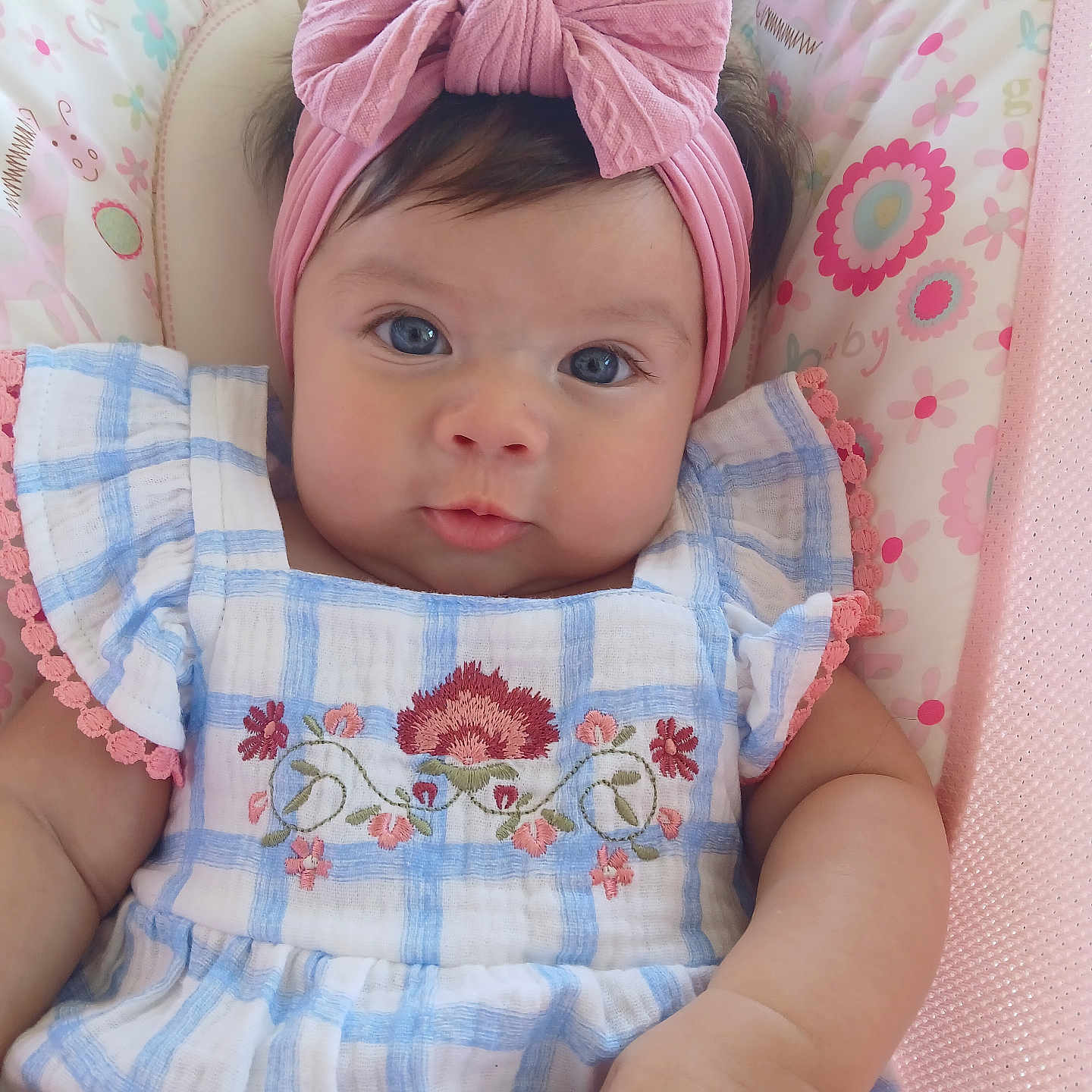 Angelina joined the competition — help win amazing prizes! baby, blue_eyes, pink_bow, headband, dress, floral_embroidery, cushion, patterned_background, infant, cute, child, closeup, portrait, soft_lighting, indoor, adorable, smiling, skin, hand, young_child