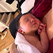 Anaya is registered to the contest to win money with this photo: newborn, baby, sleeping, towel, blanket, hand, face, infant, skin, cozy, indoor, home, stroller, stairs, floor, wooden_floor, person, relaxation, quiet, soft