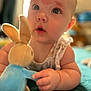 baby, infant, plush_toy, bunny, soft_toy, child, face, hand, cute, indoors, portrait, expression, skin_mark, toy, lying_down, close_up, blue, furniture, soft_focus, curious