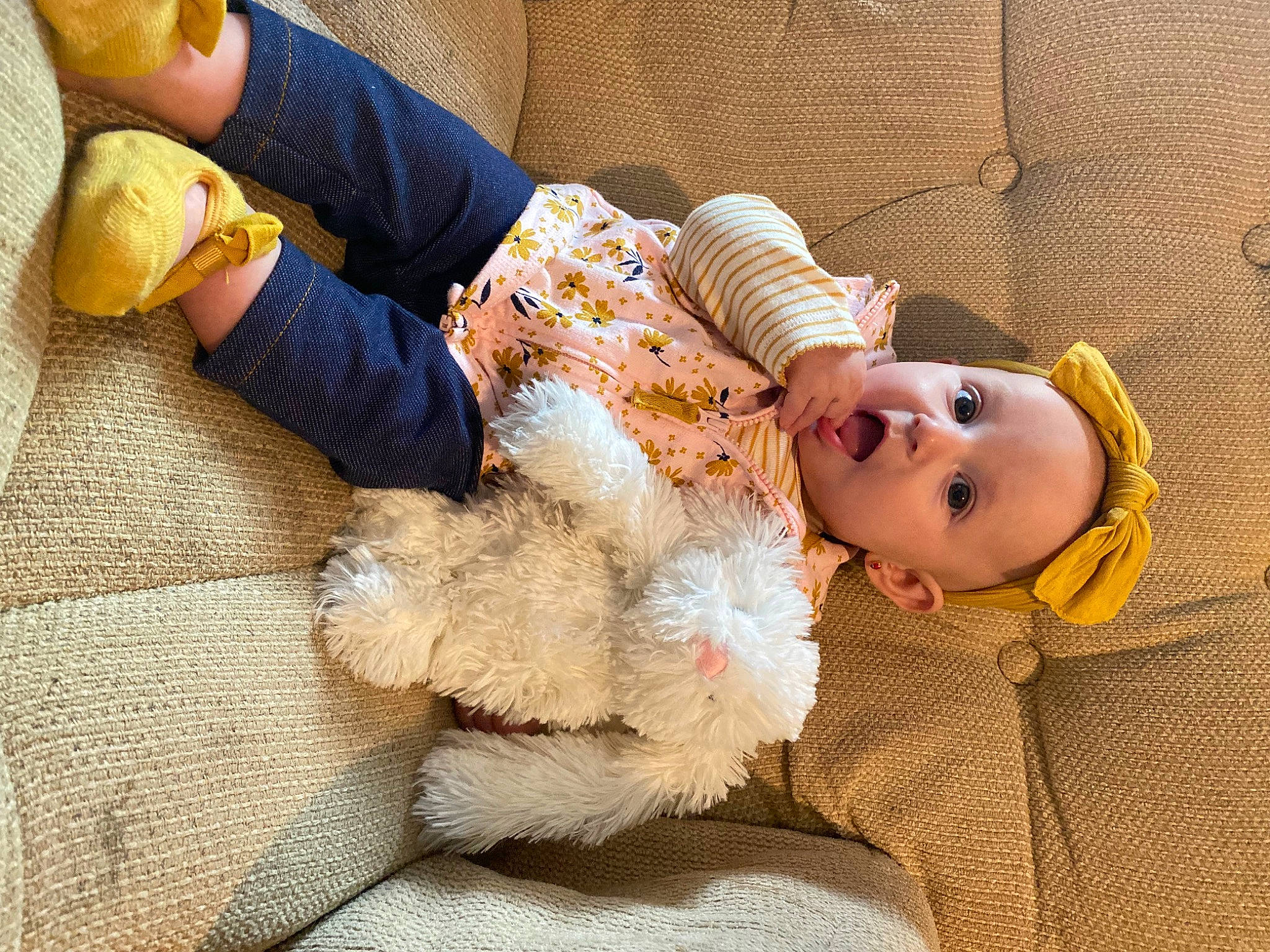 Leona is registered to the contest to win money with this photo: baby, baby_toddler_clothing, child, comfort, finger, flooring, fur, hand, happy, human_body, human_leg, linens, person, room, sitting, skin, smile, surprise, thigh, toddler