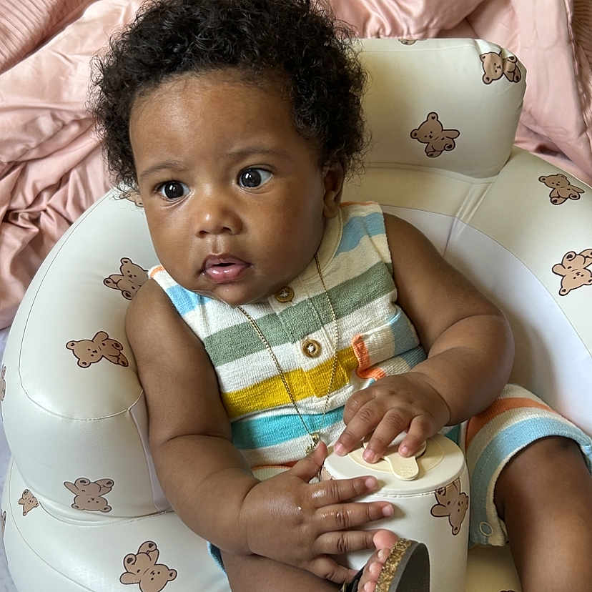 Xyliq joined the competition — help win amazing prizes! baby, bear_pattern, blanket, child, colorful, container, curly_hair, cute, expression, eyes, face, footwear, hands, indoor, infant, inflatable_chair, portrait, sandals, sitting, striped_clothing