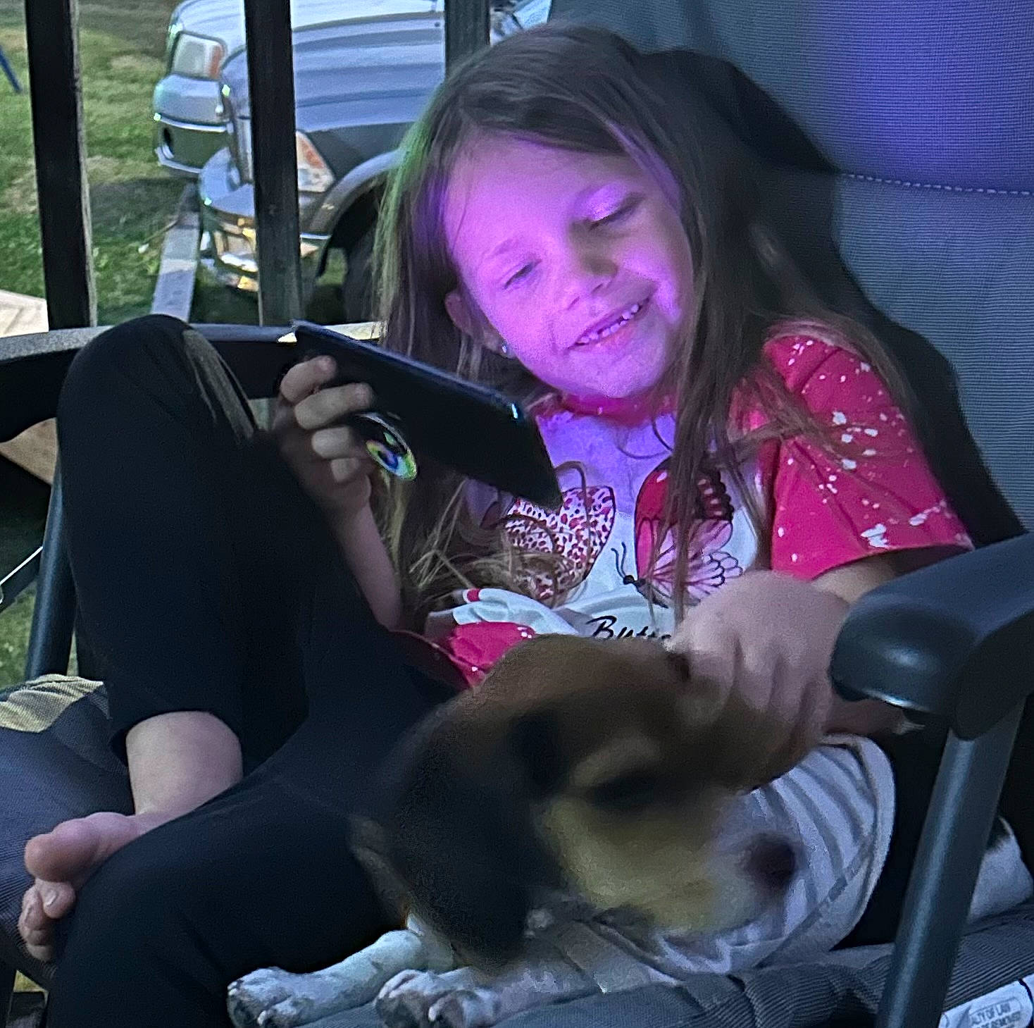 Kylie is registered to the contest to win money with this photo: auto_part, car, car_seat, carnivore, child, comfort, companion_dog, eyewear, fawn, finger, fun, happy, human_leg, joy, lap, mammal, person, sitting, smile, steering_wheel