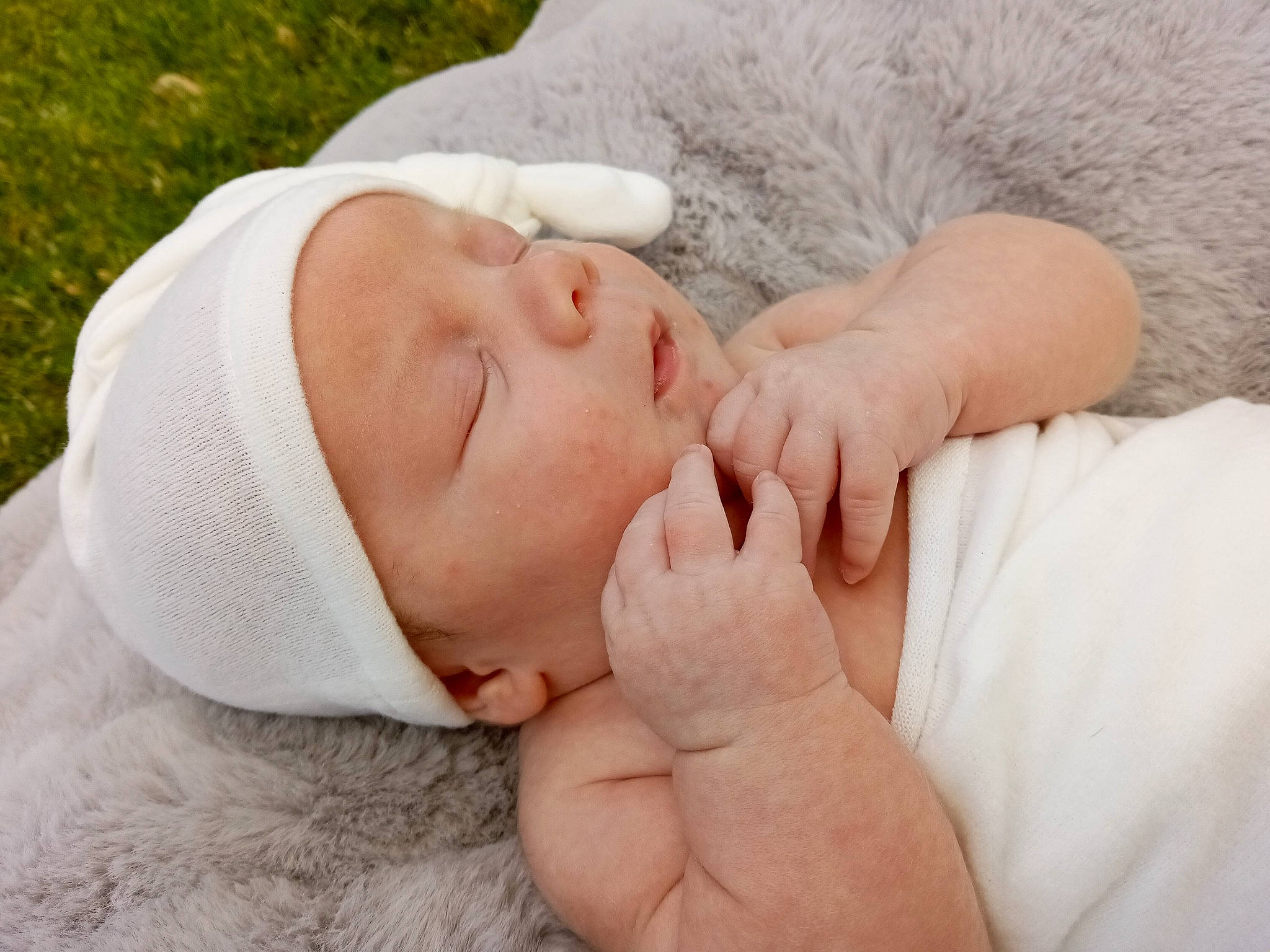 Bellamy is registered to the contest to win money with this photo: arm, baby, baby_toddler_clothing, child, close_up, comfort, eyelash, finger, flesh, gesture, grass, happy, hat, human_body, nail, person, plant, sleep, thumb, toddler
