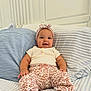 Reighlynn joined the competition — help win amazing prizes! baby, child, smiling, headband, pillow, bed, striped, floral, pants, shirt, cute, indoors, seated, comfortable, happy, person, infant, clothing, decor, portrait