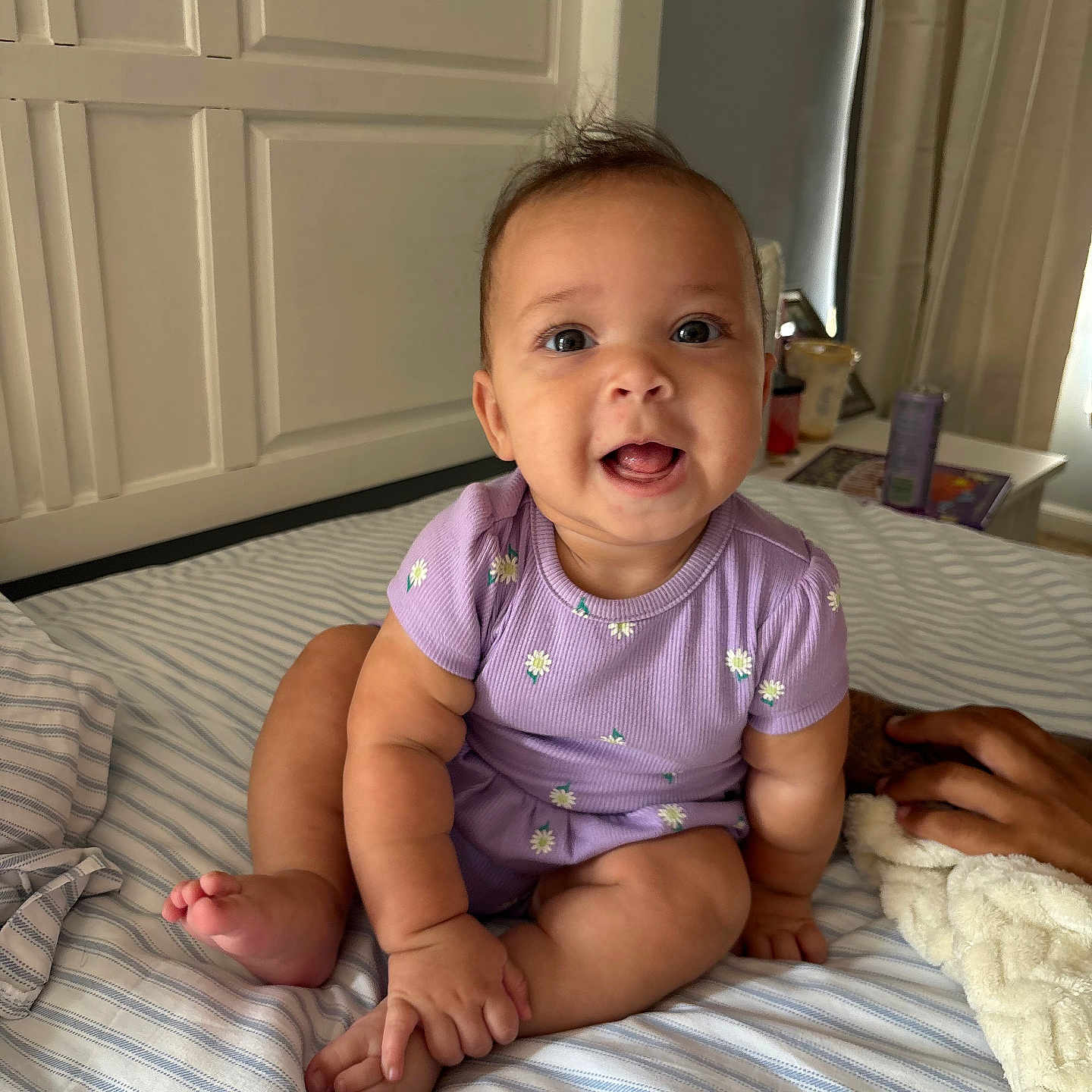 Reighlynn joined the competition — help win amazing prizes! baby, bed, blanket, child, cozy, curtains, cute, face, furniture, hand, happy, indoor, infant, onesie, person, purple_clothing, room, sitting, smiling, striped_bedspread