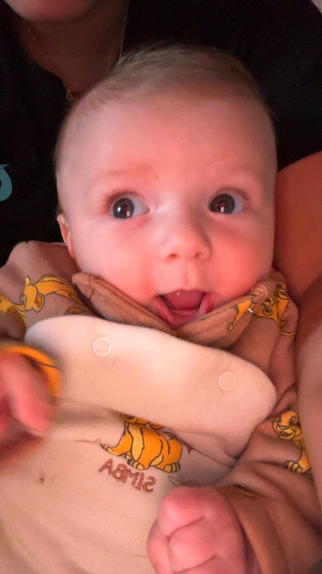 Tiago a rejoint le concours — aidez-le/la à gagner de superbes lots ! baby, infant, face, eyes, mouth_open, smile, onesie, simba, cartoon_print, clothing, close_up, portrait, hand, fingers, skin, person, cute, indoor, held, blanket