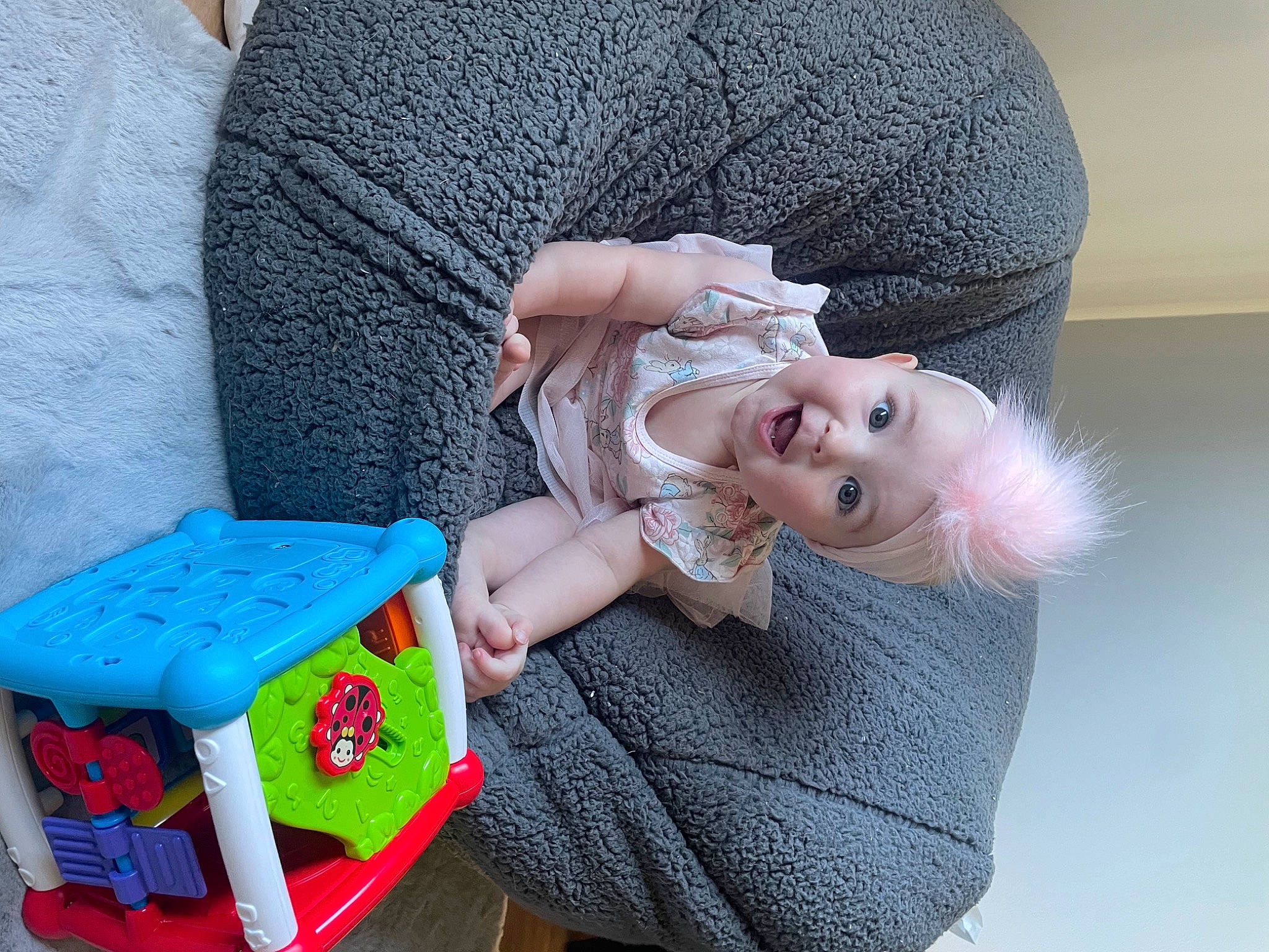 Evie joined the competition — help win amazing prizes! baby, baby_playing_with_toys, baby_products, baby_toddler_clothing, baby_toys, box, child, comfort, couch, doll, fashion_accessory, fun, headwear, person, pink, room, sitting, smile, sock, surprise
