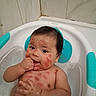baby, infant, child, bathtub, bath_time, bathwater, bath_seat, turquoise, wet, smiling, chewing, hand, bare_skin, portrait, indoor, bathroom, tiles, water, sitting, watermark
