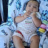 Noe Adan joined the competition — help win amazing prizes! baby, infant, child, stroller, blanket, toy, rattle, onesie, clothing, socks, portrait, face, indoors, seated, lying_down, looking_at_camera, serious_expression, colorful, soft_blanket, photograph