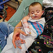 Azareé is registered to the contest to win money with this photo: baby, child, hospital, medical_tube, pacifier, blanket, adult_hand, sleeping, patient, hospital_bed, medical_tape, infant, childcare, healthcare, resting, person, closeup, indoor, care, comfort
