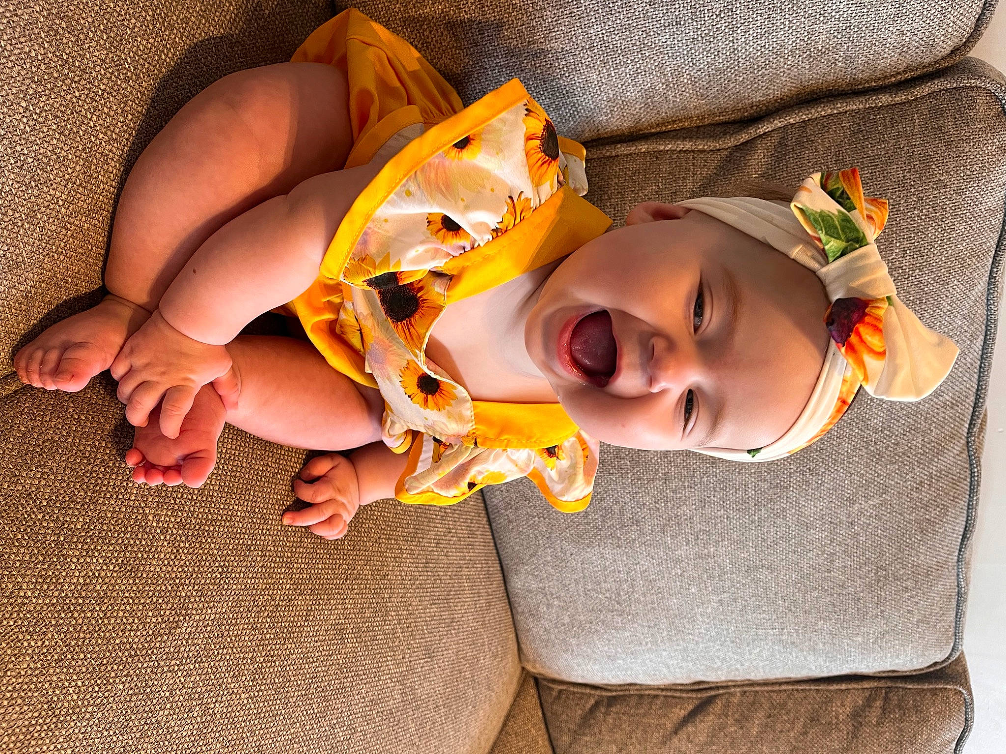 Aurora is registered to the contest to win money with this photo: baby, baby_toddler_clothing, child, comfort, facial_expression, finger, foot, fun, happy, hat, head, headwear, human_body, human_leg, linens, mouth, orange, person, skin, smile