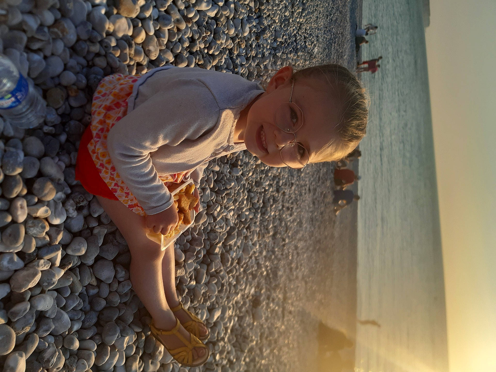 Eloïse a rejoint le concours — aidez-le/la à gagner de superbes lots ! beach, blue, body_of_water, foot, fun, happy, human_body, human_leg, leg, leisure, people_in_nature, person, sand, shadow, smile, standing, sunlight, toddler, tree, water