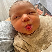 Angela a rejoint le concours — aidez-le/la à gagner de superbes lots ! baby, infant, face, tongue, expression, cute, child, clothing, beige, person, portrait, closeup, cozy, resting, soft_texture, indoor, human, newborn, funny_face, bear_design