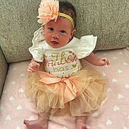 Leilani is registered to the contest to win money with this photo: accessories, baby, clothing, costume, couch, cushion, dress, face, flower, furniture, head, homedecor, newborn, person, petal, photography, plant, portrait, sitting, skirt