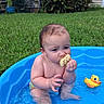 baby, child, infant, outdoor, backyard, swimming_pool, water, rubber_duck, toy, snack, eating, sitting, blue_water, grass, garden, plants, house, portrait, summer, playtime