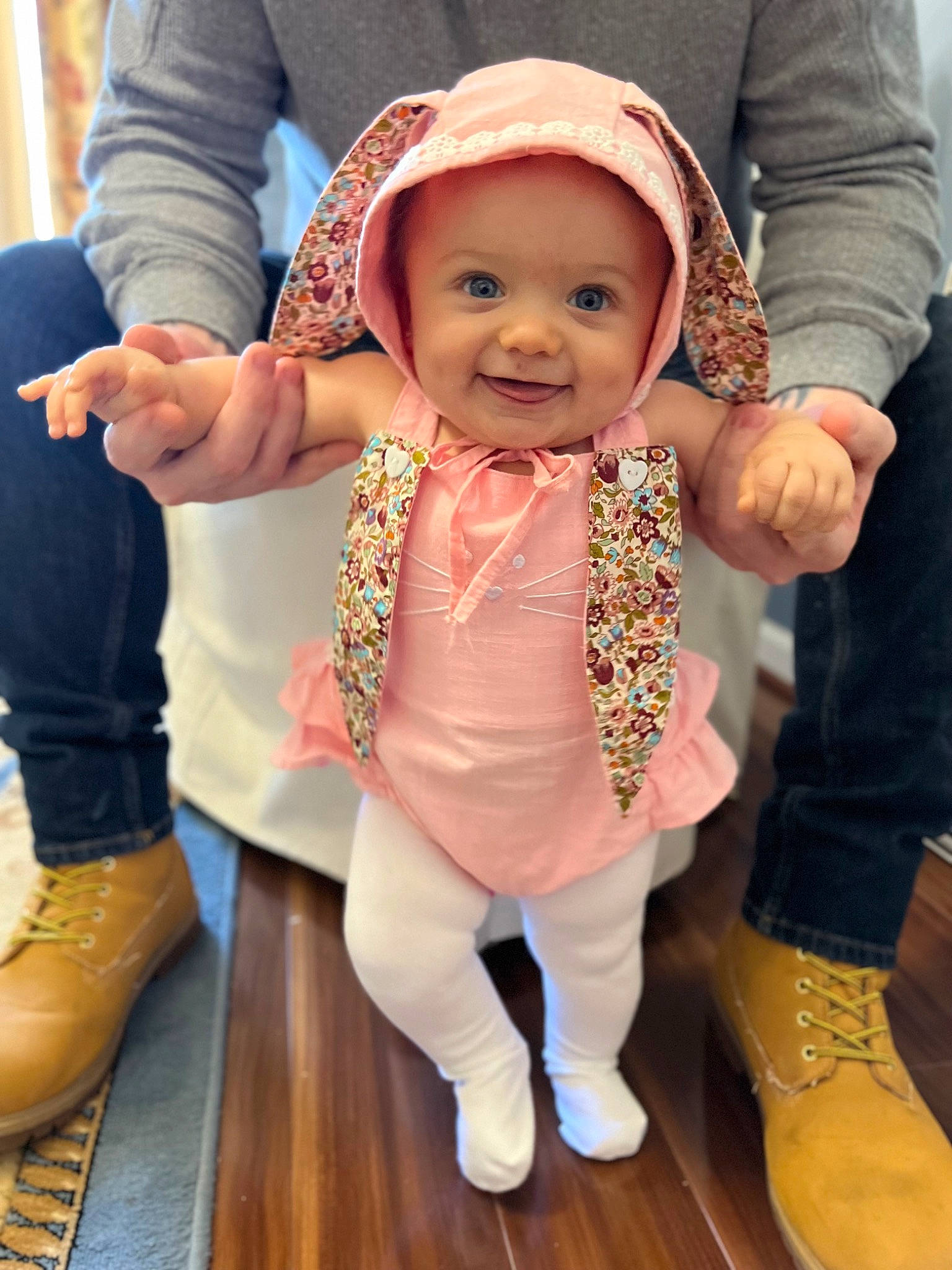 Penelope is registered to the contest to win money with this photo: baby, baby_toddler_clothing, cheek, child, event, eye, face, flooring, gesture, happy, hat, head, headwear, human_leg, joy, person, shoe, skin, sleeve, smile