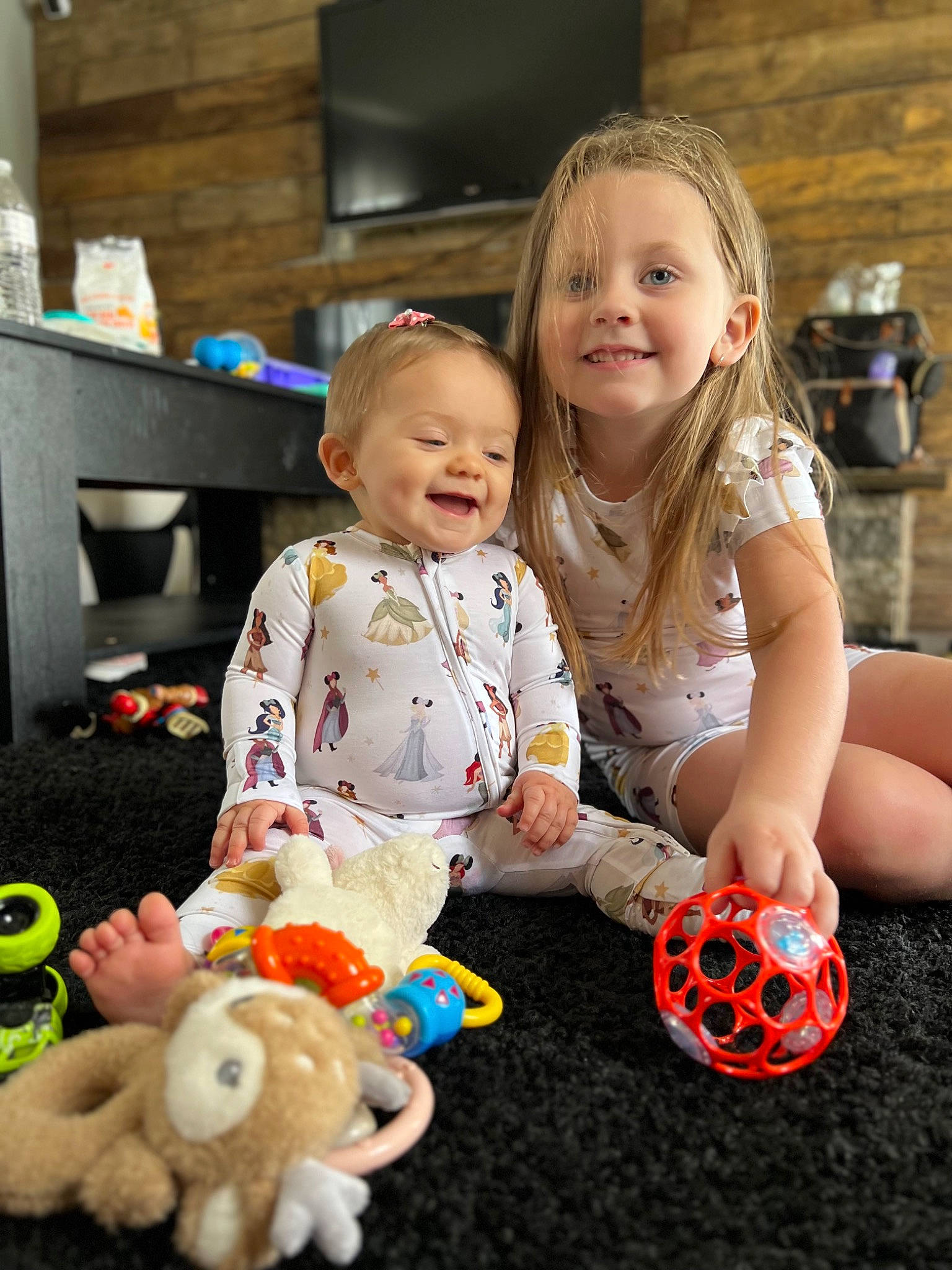 Penelope is registered to the contest to win money with this photo: baby, baby_toddler_clothing, child, event, flooring, fun, happy, head, joy, mammal, people, person, play, sitting, skin, smile, snapshot, stuffed_toy, television, toddler