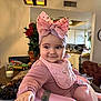 Azalea is registered to the contest to win money with this photo: baby, pink_bow, baby_seat, bumbo_seat, bib, indoor, kitchen, roses, flowers, table, grapes, milk, toy_car, cheerful, child, infant, person, smiling, headband, clothing