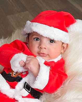 Eleazar is registered to the contest to win money with this photo: baby, baby_toddler_clothing, child, christmas, christmas_eve, costume_hat, event, fictional_character, fun, fur, fur_clothing, happy, hat, headwear, holiday, human_body, lap, person, santa_claus, sleeve