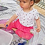 Emma participe au concours pour gagner de l'argent avec cette photo : child, toddler, girl, pink_pants, white_shirt, ladybug_pattern, ponytail, plastic_containers, macaroni, rice, blanket, fence, outdoor, playing, sitting, serious_expression, toy, floor, hair_tie, daylight
