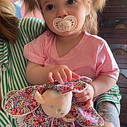 Emma a rejoint le concours — aidez-le/la à gagner de superbes lots ! toddler, child, pacifier, plush_toy, pigtails, pink_shirt, striped_shirt, tattoo, balloons, indoor, hand, face, person, toy, purple_pants, cute, baby, holding, sitting, portrait