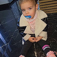 Jordana a rejoint le concours — aidez-le/la à gagner de superbes lots ! black_marble_floor, casual_clothing, child, curious, cute, floor, footwear, hair_tied, indoor, jacket, long_pants, looking, pacifier, person, pink_sneakers, portrait, shearling, sitting, toddler, young_child