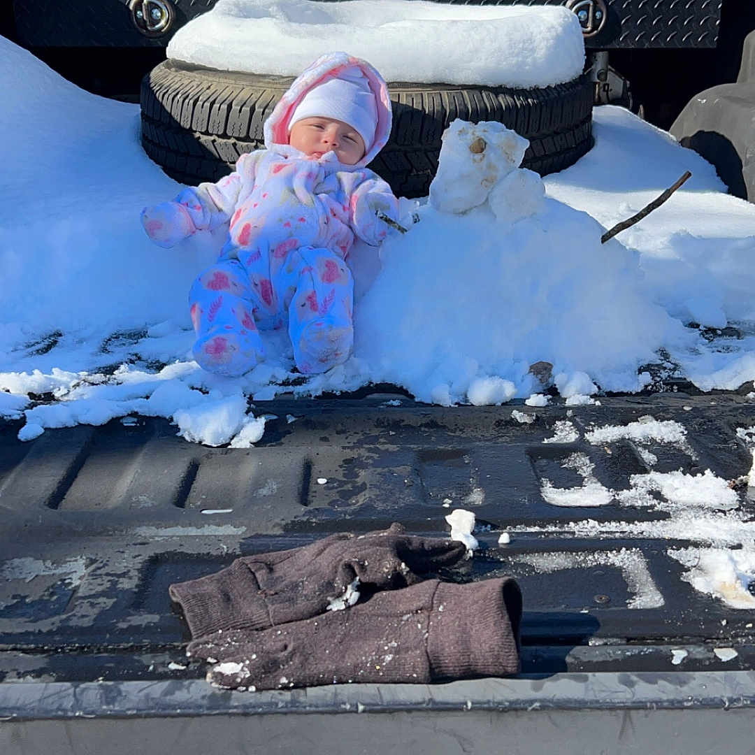 Delilah joined the competition — help win amazing prizes! baby, cap, clothing, face, glove, hat, head, machine, nature, outdoors, person, photography, pickuptruck, portrait, soil, transportation, truck, vehicle, wheel, winter
