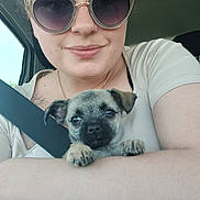 Bobby participe au concours pour gagner de l'argent avec cette photo : person, puppy, dog, sunglasses, car, seatbelt, arm, smile, cute, pet, window, casual_clothing, closeup, indoor, young_adult, portrait, animal, companion, happy, resting