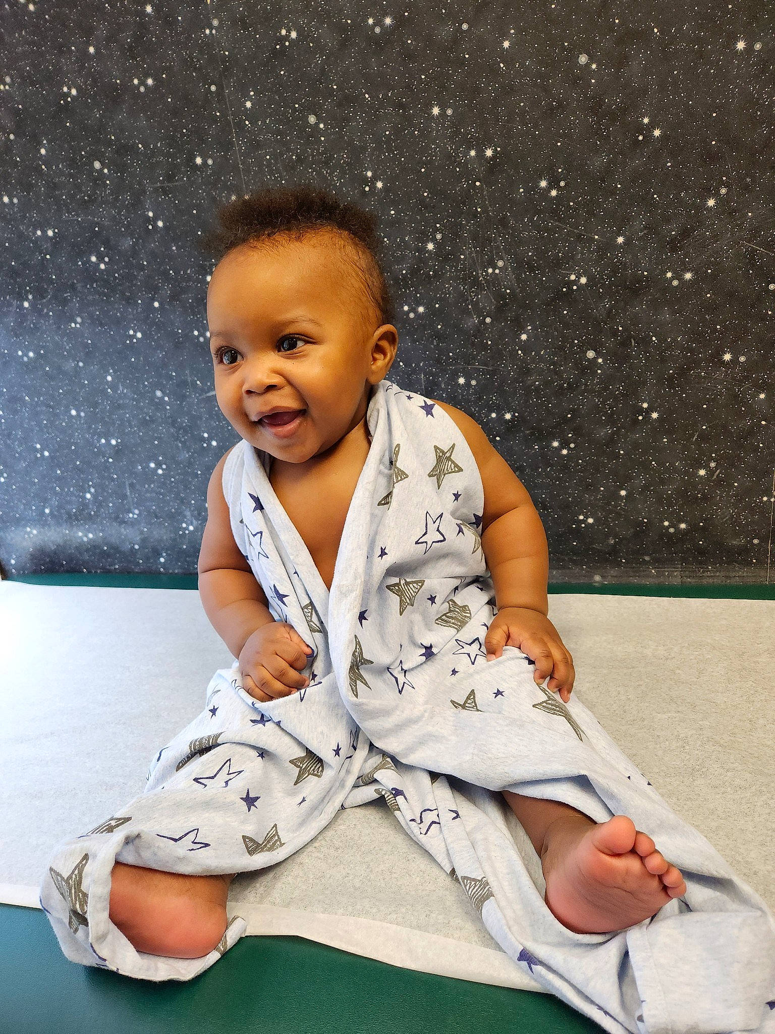 Malik is registered to the contest to win money with this photo: baby, baby_toddler_clothing, barefoot, cheek, child, comfort, elbow, flash_photography, flooring, foot, fun, happy, head, human_leg, person, sitting, sleeve, smile, thigh, thumb